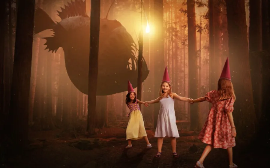 Tres niñas gorros rojos en punta van caminando de la mano por un bosque al atarceder