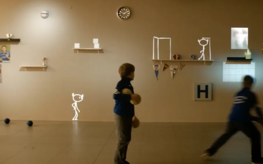 Niños juegan contra una pared con diferentes figuras y objetos