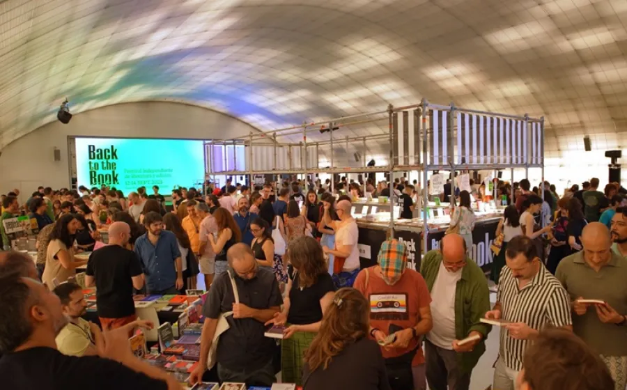 Gente ojea libros en un gran espacio cubierto