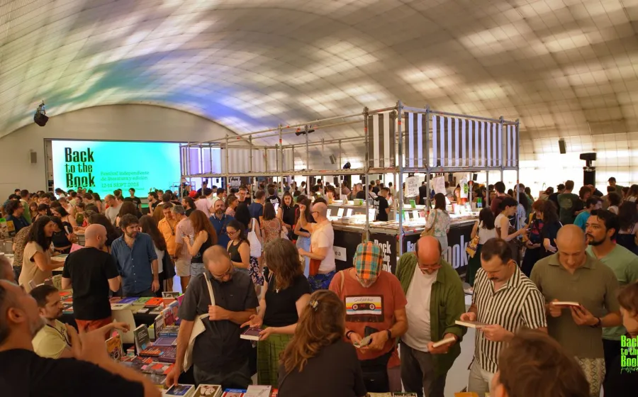 Gente asiste a una feria en un recinto cubierto