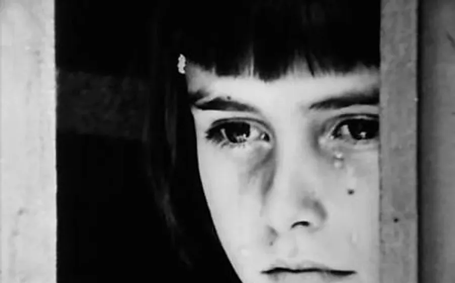 Rostro de niño llorando en blanco y negro mirando al infinito