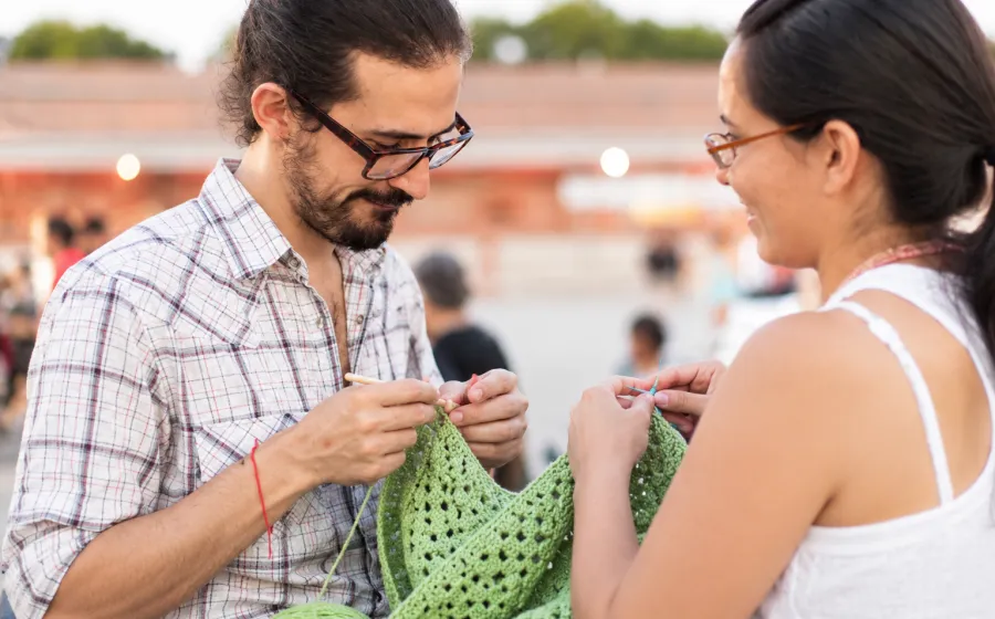Pareja tejiendo al aire libre