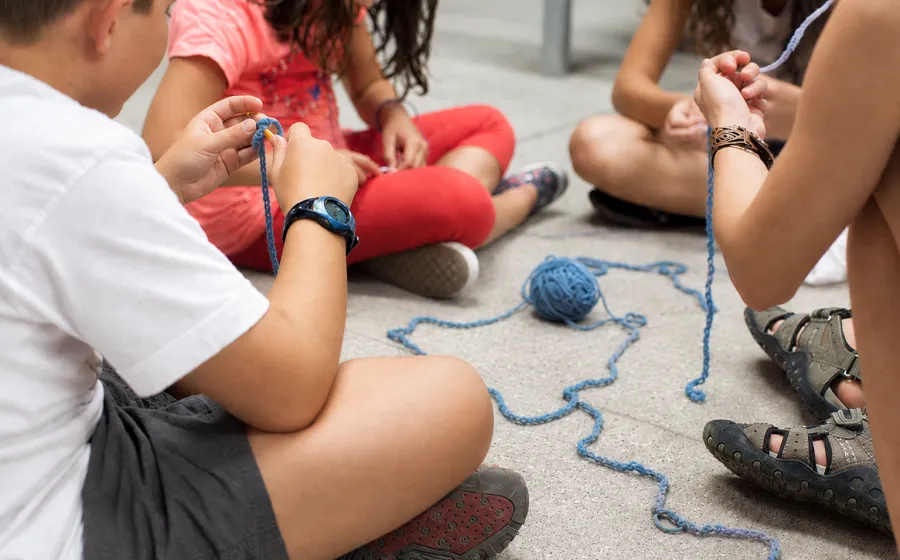 Niñas y niños juegan con hilos