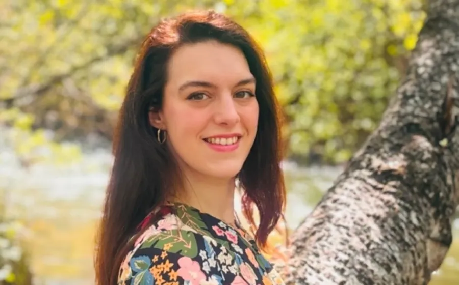 chica mira a cámara de perfil con un árbol de fondo