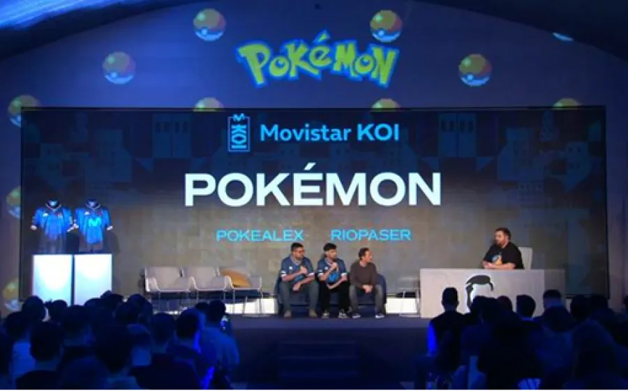 Ponentes hablan sobre un escenario con una pantalla de fondo con el texto Pokemon