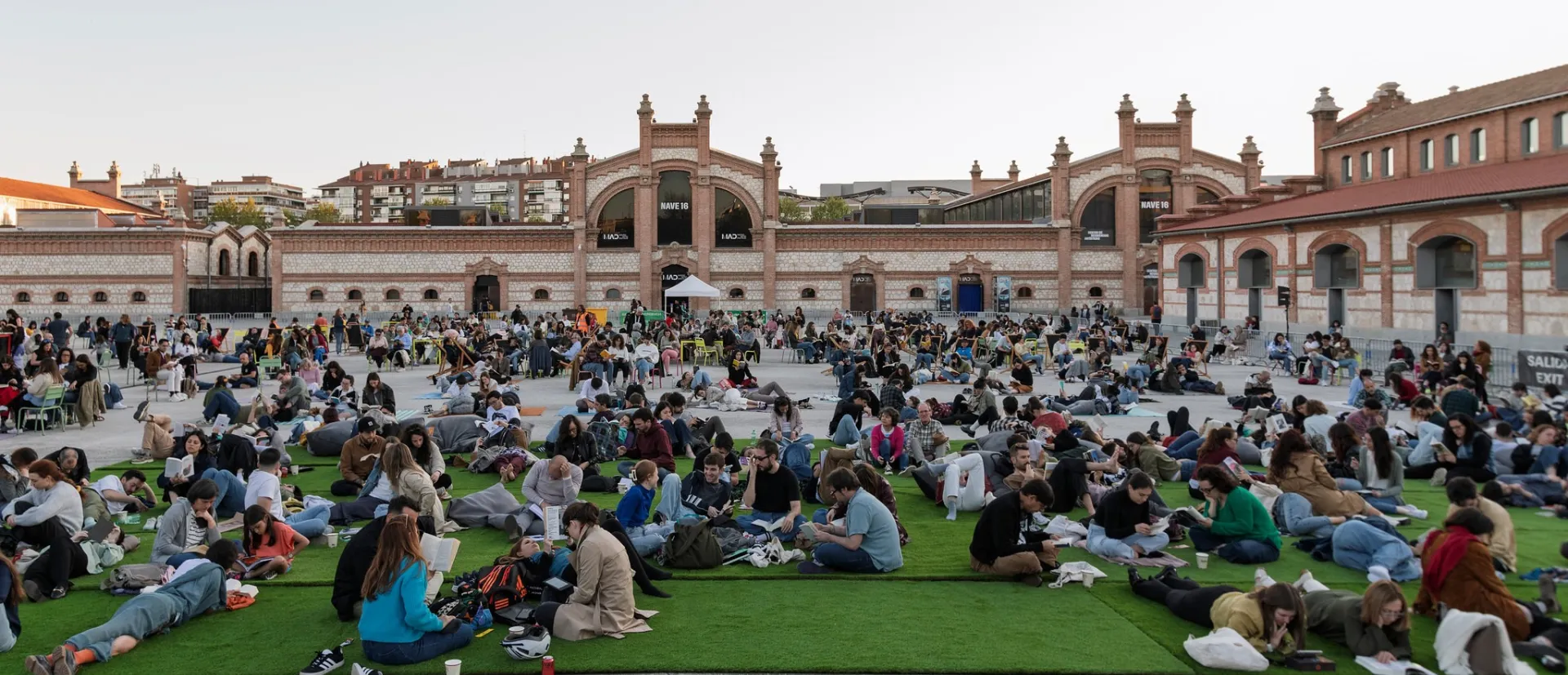 Gente leyendo sentada en una plaza