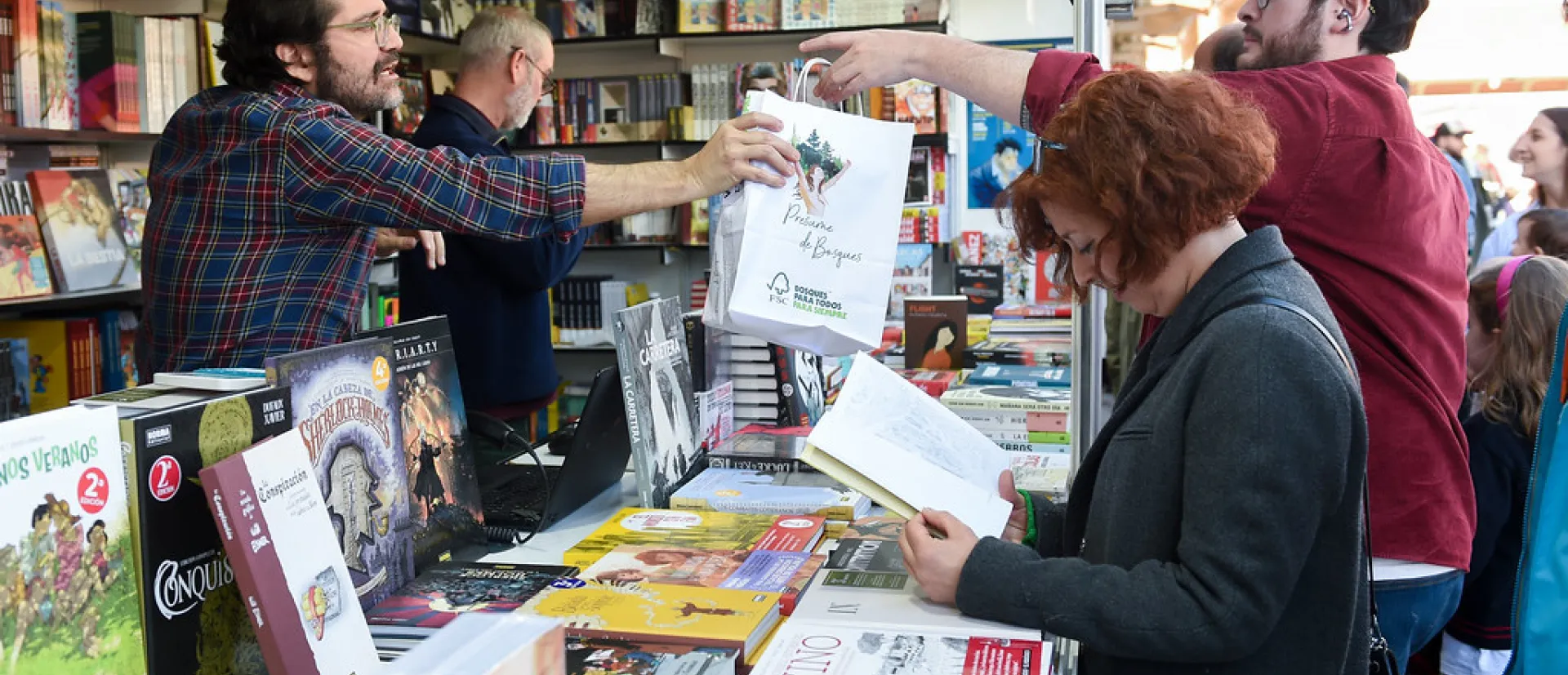 Gente comprando comics en una caseta