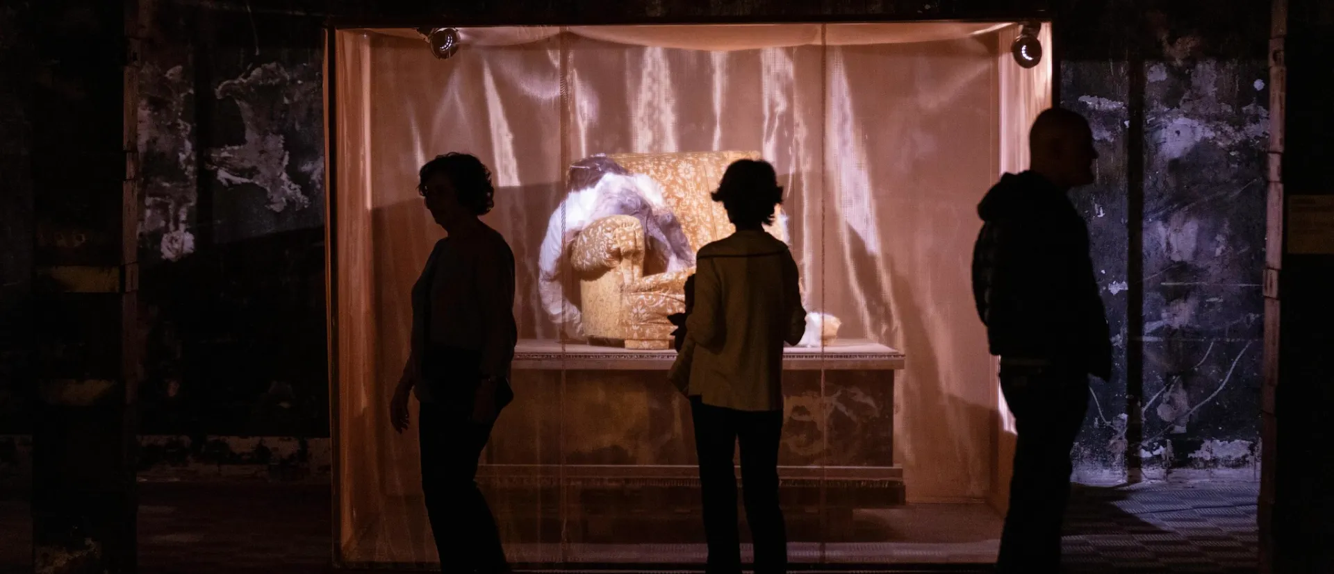 Siluetas contemplan una obra de arte iluminada