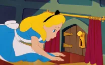 Niña rubia mira una puerta en miniatura