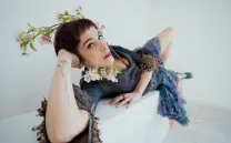 Chica con florecillas en la cabeza tumbada en un diván