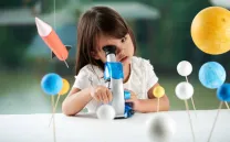 Niña mirando por un microscopio