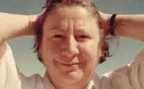 Mujer sonríe con las manos tras la nuca