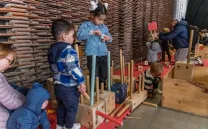 niñas y niños juegan con piezas de madera