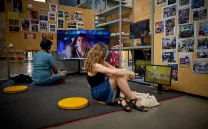 Chica y chico sentados en el suelo observan obras de arte