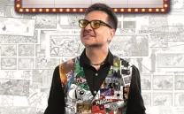 Chico con gafas y chaleco estampado con manos abiertas