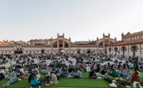 Gente leyendo sentada en una plaza