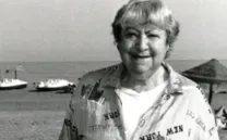 Fotografía de Gloria Fuertes en blanco y negro con barcos de fondo