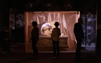 Siluetas contemplan una obra de arte iluminada