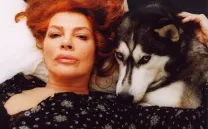 Rostro de mujer tumbada junto al de un perro husky