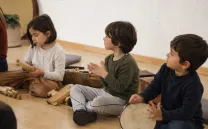 TRES NIÑOS SENTADOS EN EL SUELO