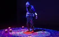 Una figura humana con capucha bajo luces de colores