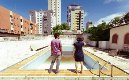 Una pareja observa una piscina vacía