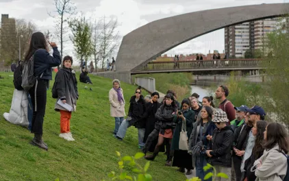 Grupo de gente atiende a una mujer que les habla en un parque