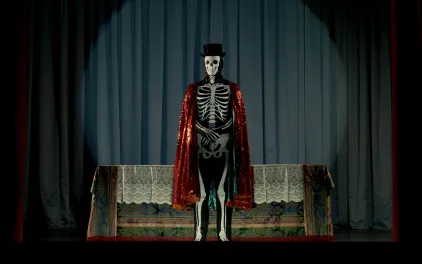 Una persona vestida de esqueleto con una chistera