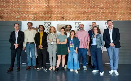 Grupo de personas posan frente a cartel oficial de DOCUMENTA MADRID