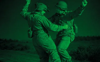 Fotografía con filtro verde en la que dos soldados bailan cogidos de la cintura 